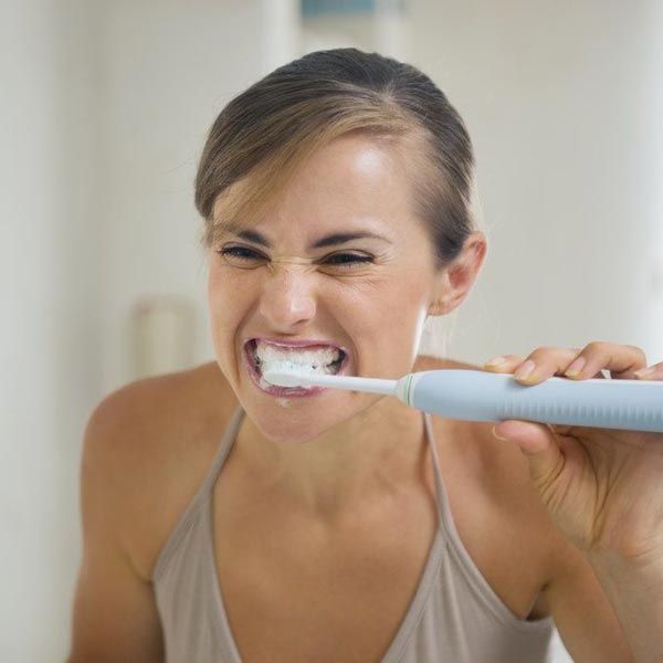 Woman using electric toothbrush